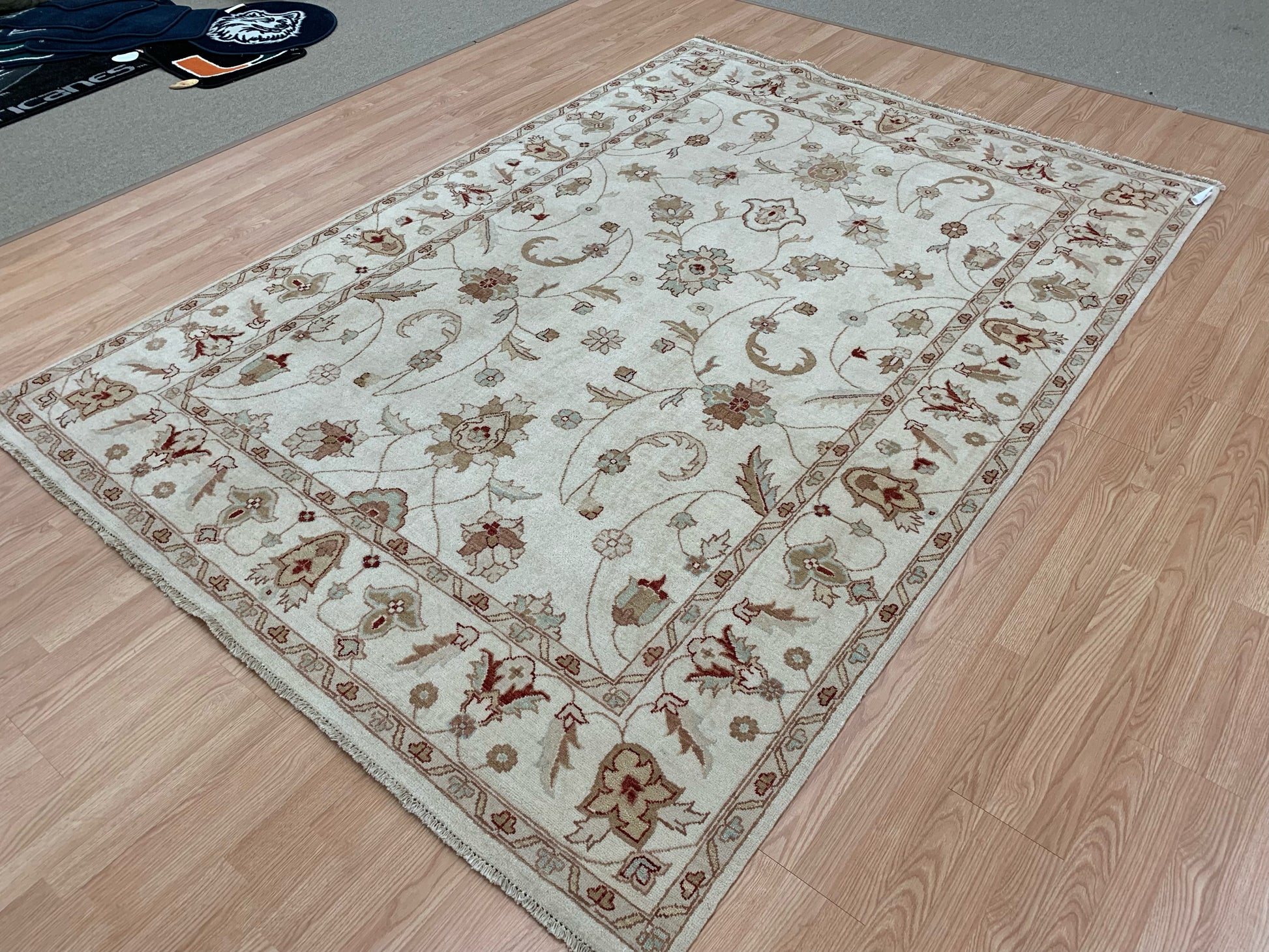 6’7"x9’4” hand-knotted wool Oushak rug in ivory on wood floor