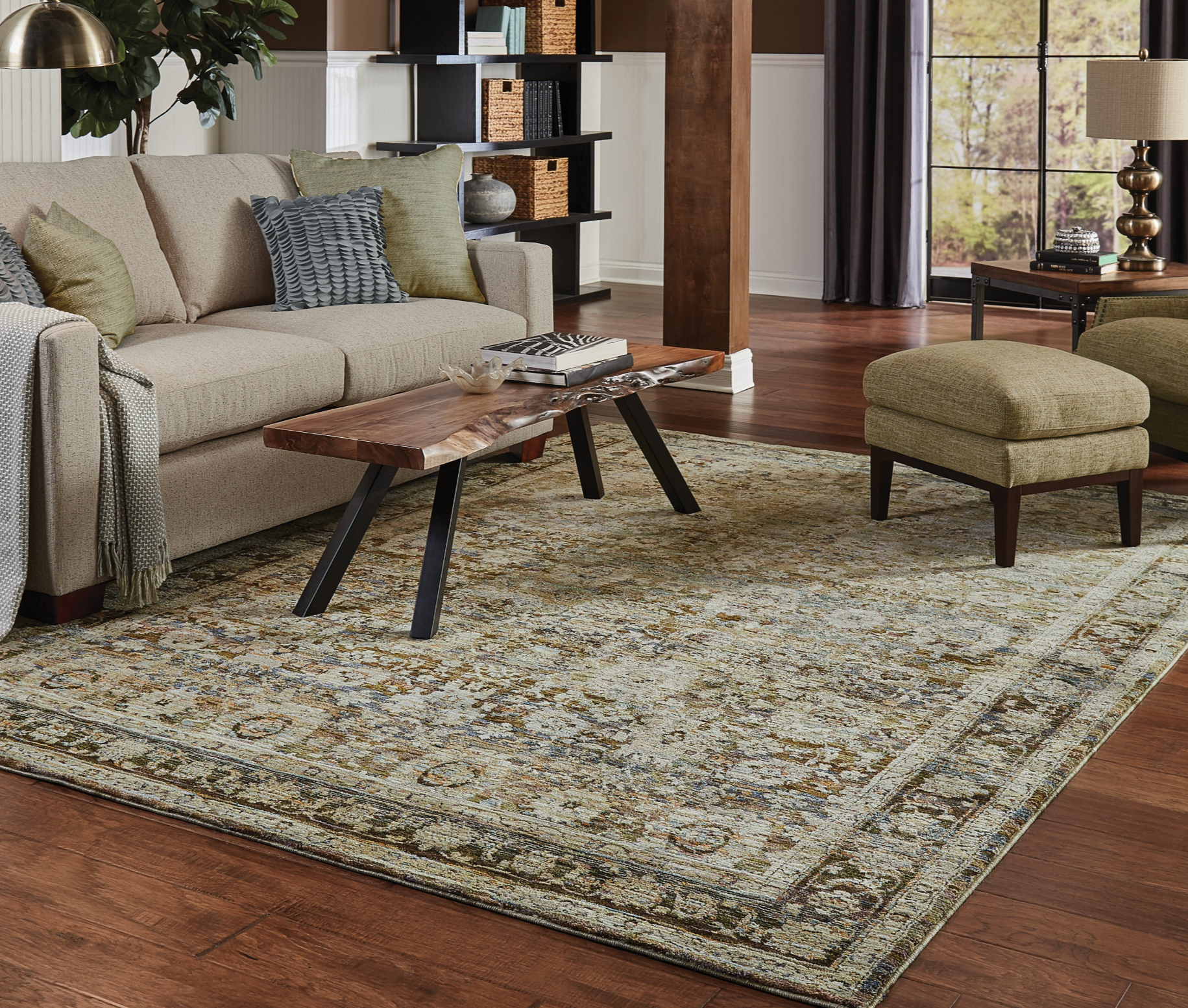 Living room with a beige sofa, coffee table, and ottoman on a patterned rug.