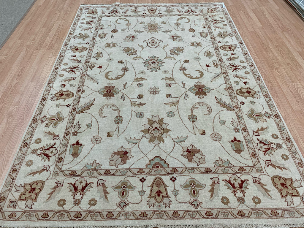 6’7"x9’4” hand-knotted wool Oushak rug in ivory straight on wood floor