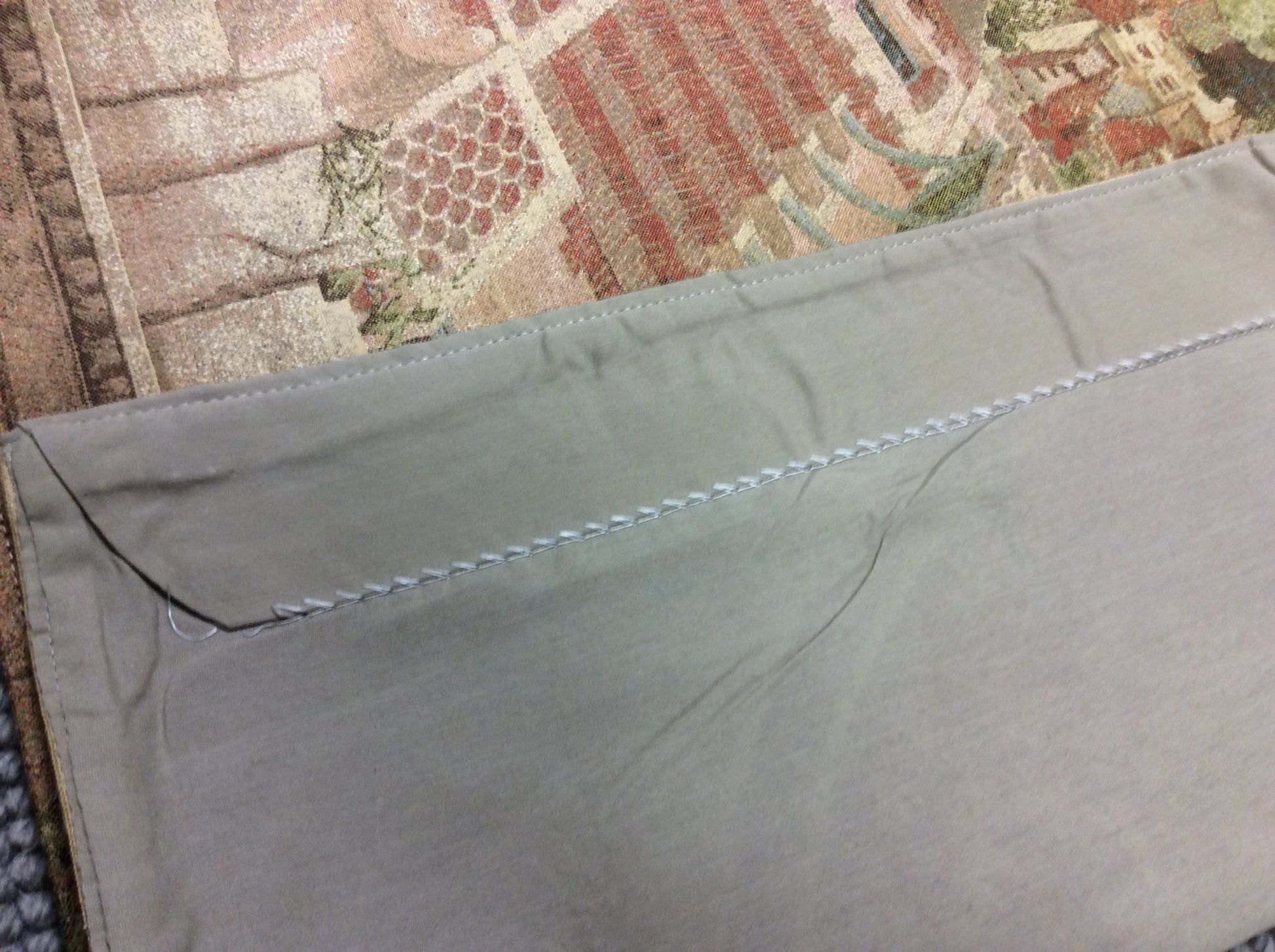 Top Back View of Hillside Town Tapestry - Quality craftsmanship with durable fabric and rod sleeve for easy hanging.